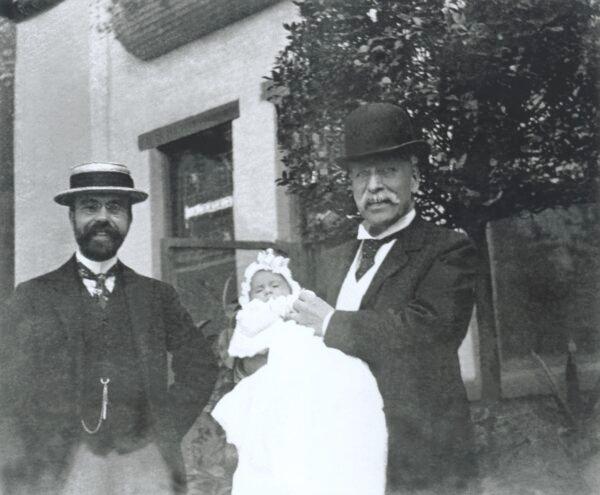 Villard (R) holds his first grandson, Henry Serrano, with his son Harold beside them. (Courtesy of Alexandra Villard de Borchgrave)