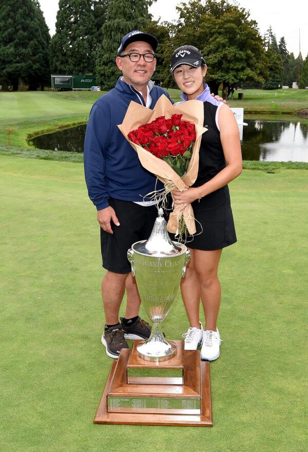Andrea Lee poses with the trophy and her father James Lee after winning the AmazingCre Portland Classic at Columbia Edgewater Country Club in Portland, Ore., on September 18, 2022. (Steve Dykes/Getty Images)