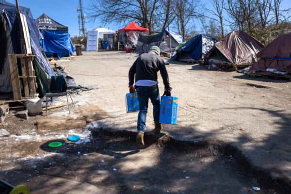 A man brings shoplifted beer to sell at a homeless encampment on March 12, 2022, in Seattle, Washington. Stolen goods are sold for cash or drugs, currently most often fentanyl. (John Moore/Getty Images)