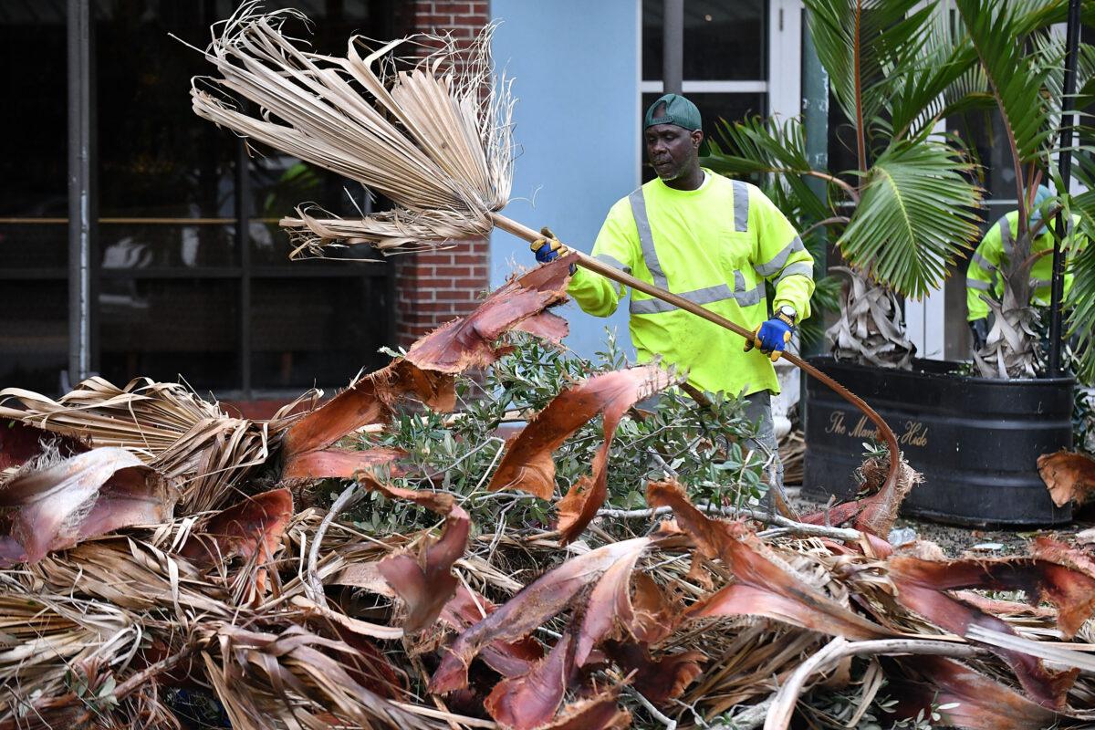 A local worker cleans debris in downtown Saint Petersburg after Hurricane Ian passed through the area in Saint Petersburg, Fla., on September 29, 2022. (Gerardo Mora/Getty Images)