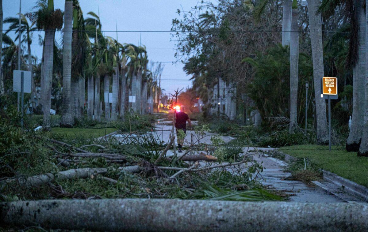 A man walks through debris on a street in the aftermath of Hurricane Ian in Punta Gorda, Fa., on Sept. 29, 2022. (Ricardo Aarduengo/AFP via Getty Images)