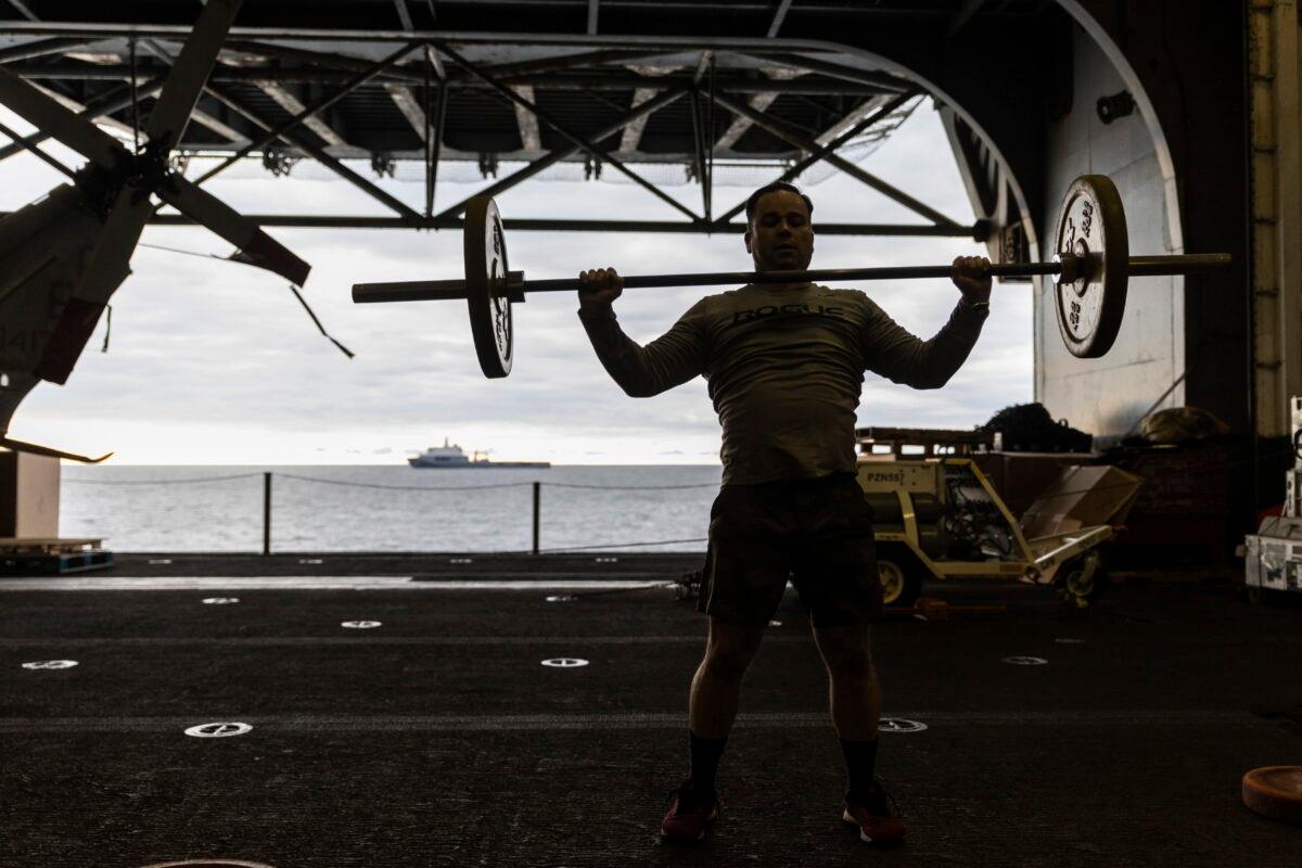 A U.S. soldier works out in the hangar at the the Wasp-class amphibious assault ship USS Kearsarge (LHD 3) operating in the Baltic Sea on Sept. 2, 2022. (Michal Dyjuk/AP Photo)