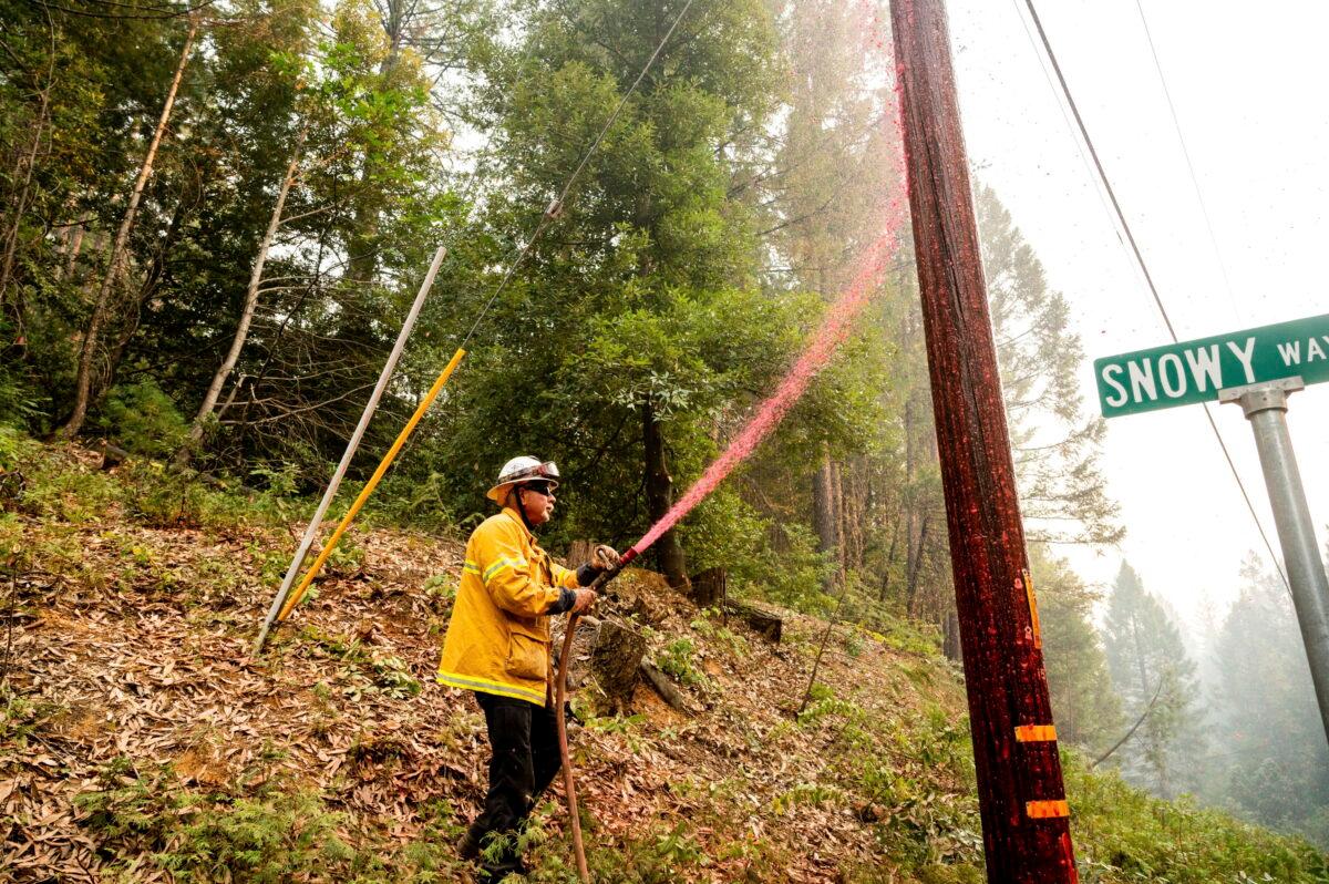 Pacific Gas & Electric firefighter Dave Ronco sprays retardant on a utility pole to protect infrastructure as the Mosquito Fire burns near Volcanoville in El Dorado County, Calif., on Sept. 9, 2022. (Noah Berger/AP Photo)