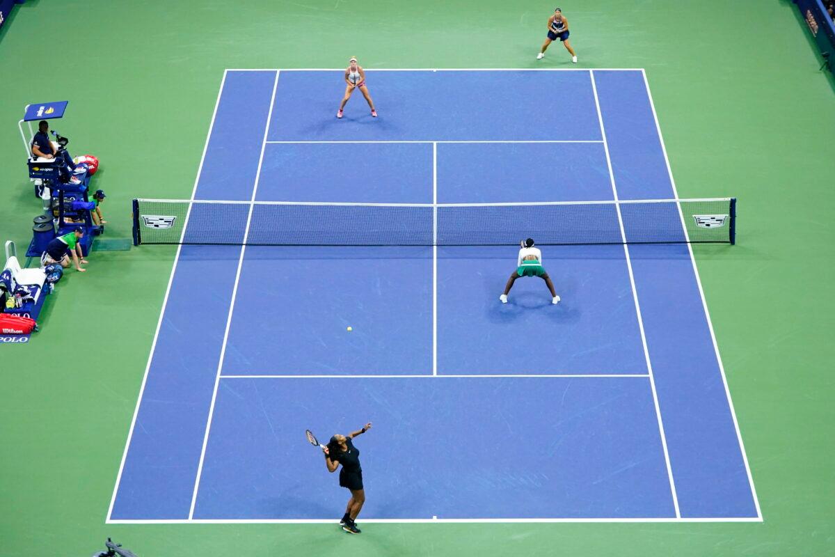 Serena Williams, lower left, serves along side Venus Williams of the United States during their first-round doubles match against Lucie Hradecká, top right, and Linda Nosková of the Czech Republic at the U.S. Open tennis championships in New York on Sept. 1, 2022. (Frank Franklin II/AP Photo)