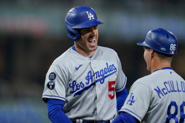 Los Angeles Dodgers' Freddie Freeman, left, celebrates with first base coach Clayton McCullough after hitting an RBI single during the sixth inning of the team's baseball game against the San Diego Padres, in San Diego, on Sept. 29, 2022. (Gregory Bull/Getty Images)