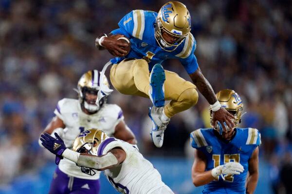 UCLA quarterback Dorian Thompson-Robinson (1) leaps over Washington linebacker Kamren Fabiculanan during the first half of an NCAA college football game in Pasadena, Calif., on Sept. 30, 2022. (Marcio Jose Sanchez/AP Photo)