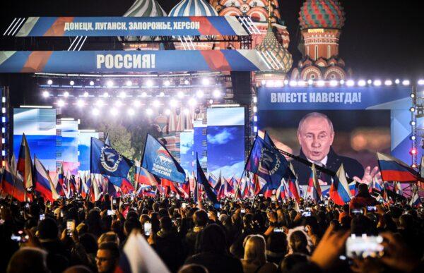 Russian President Vladimir Putin is seen on a screen set at Red Square as he addresses a rally and a concert marking the annexation of four regions of Ukraine occupied by Russian troops—Lugansk, Donetsk, Kherson, and Zaporizhzhia—in Moscow on Sept. 30, 2022. (Alexander Nemenov/AFP via Getty Images)