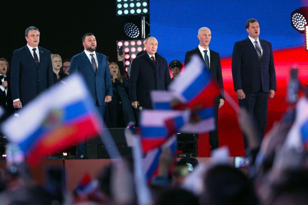Russian President Vladimir Putin (C) sings the national anthem during a rally and a concert marking the annexation of four regions of Ukraine Russian troops occupy - Lugansk, Donetsk, Kherson, and Zaporizhzhia, at Red Square in central Moscow on Sept. 30, 2022. (Anton Novoderezhkin/SPUTNIK/AFP via Getty Images)