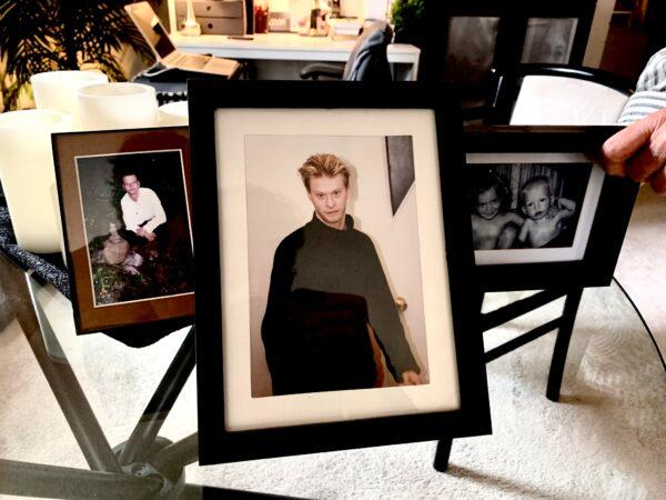 Sharon Danley presents several framed photos of her son, Matthew, in her Toronto apartment on Sept. 27, 2022. (Peter Wilson/The Epoch Times)