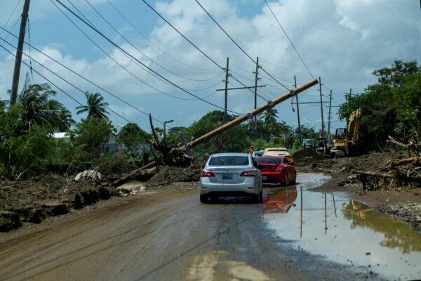Cars drive under a downed power pole in the aftermath of Hurricane Fiona in Santa Isabel, Puerto Rico, on Sept. 21, 2022. (Ricardo Arduengo/Reuters)