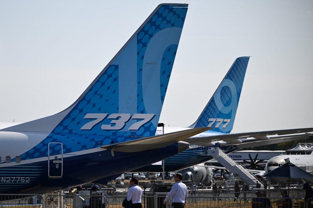 Visitors walk past a Boeing 737 (L) and a Boeing 777 (R) displayed during the Farnborough Airshow, in Farnborough, on July 18, 2022. (Justin Tallis/AFP via Getty Images)