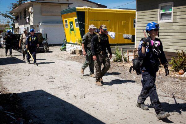 FEMA agents and Lee County Sheriff officers walk by a trailer park after Hurricane Ian caused widespread destruction in Fort Myers Beach, Fla., on Oct. 3, 2022. (Marco Bello/Reuters)