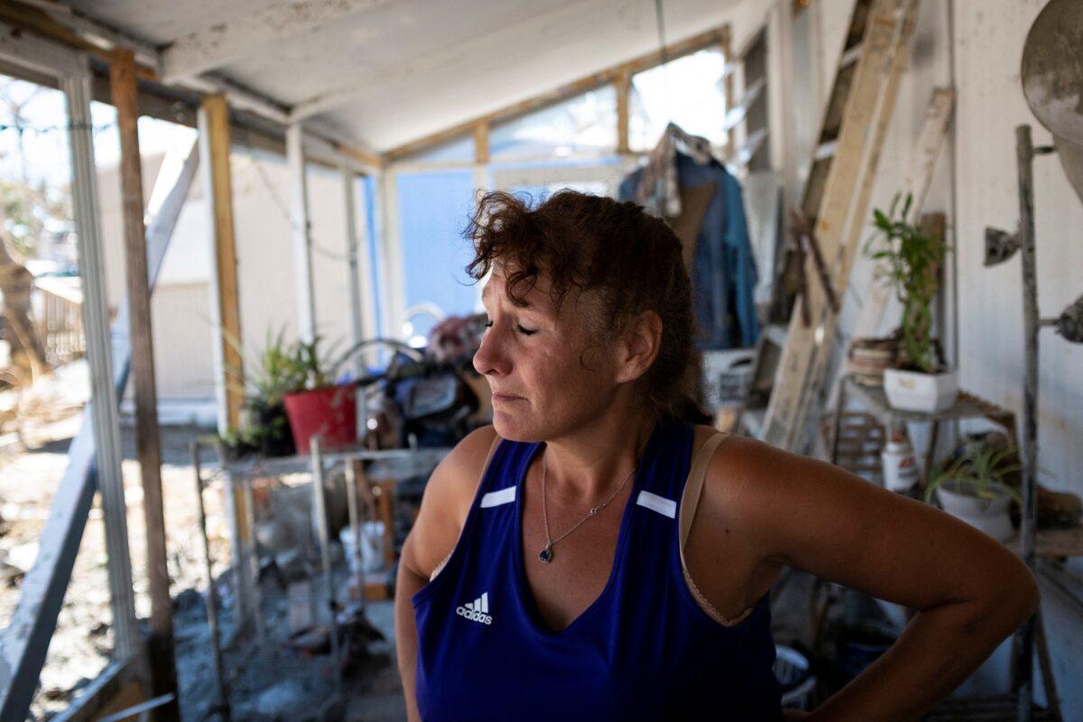 Temple Condon reacts as she poses for a portrait at her home after Hurricane Ian caused widespread destruction in Fort Myers Beach, Fla., on Oct. 3, 2022. (Marco Bello/Reuters)