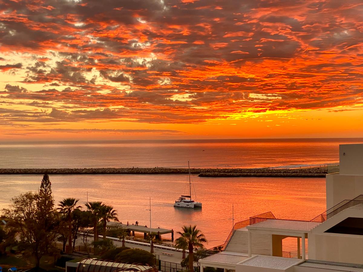 A sailboat comes back to the marina in Vilamoura under a blazing sunset. (Tim Johnson)