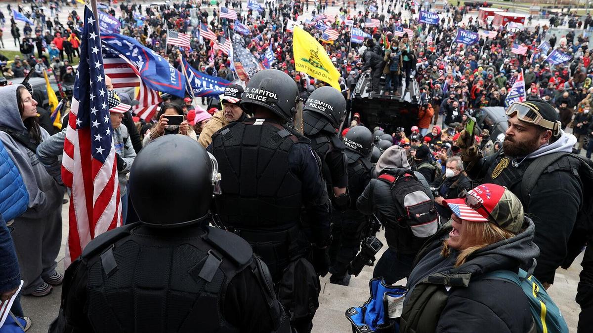 Capitol Police are escorted down the Capitol steps through the crowd to safety by members of the Oath Keepers at the U.S. Capitol in Washington on Jan. 6, 2021. Oath Keeper Roberto Minuta is at right, with goggles on his head. (Courtesy of Roberto Minuta)