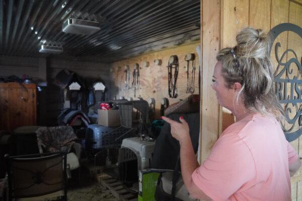 Punta Gorda resident Lisa Motteler points to a tack room in her horse barn where she rode out Hurricane Ian on Sept. 28, 2022, along with her husband and six dogs. (Jann Falkenstern/The Epoch Times)