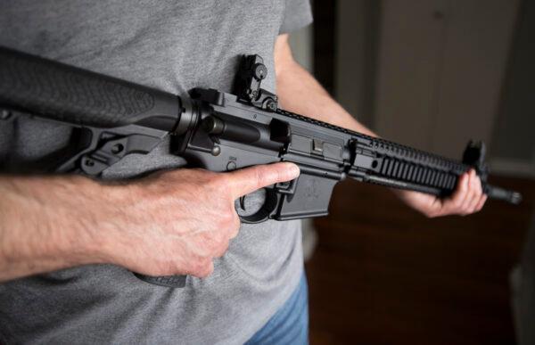 A restricted gun licence holder holds a AR-15 at his home in Langley, B.C., on May 1, 2020. (The Canadian Press/Jonathan Hayward)