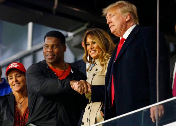 Former football player and political candidate Herschel Walker interacts with former U.S. President Donald Trump prior to Game Four of the World Series between the Houston Astros and the Atlanta Braves at Truist Park in Atlanta, Ga., on Oct. 30, 2021. (Michael Zarrilli/Getty Images)