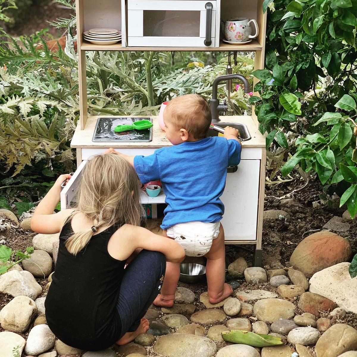 Evelyn and Christopher playing in the "mud kitchen." (Courtesy of <a href="https://www.instagram.com/mykidsaredirtyagain/">Taylor Raine</a>)
