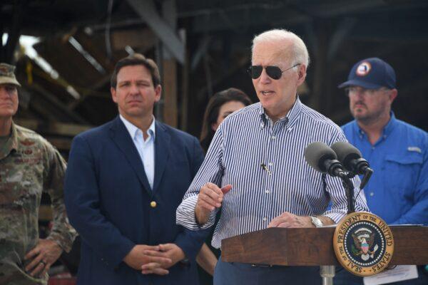 President Joe Biden speaks in a neighborhood impacted by Hurricane Ian at Fishermans Pass in Fort Myers, Fla., on Oct. 5, 2022, as Florida Governor Ron DeSantis looks on. (Olivier Douliery/AFP via Getty Images)