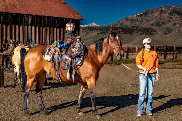 Eighteen-year-old Aspen Wright guides her little nephew Leland on a horse. Maria Coulson for American Essence)