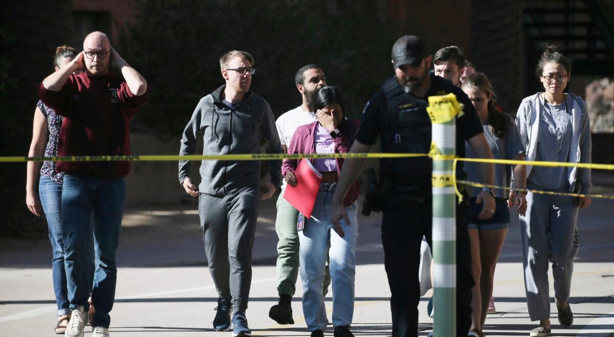 University of Arizona Police escort students from the scene of a shooting at the John W. Harshbarger Building on the University of Arizona campus in Tucson, Ariz., on Oct. 5, 2022. (Rebecca Sasnett/Arizona Daily Star via AP)