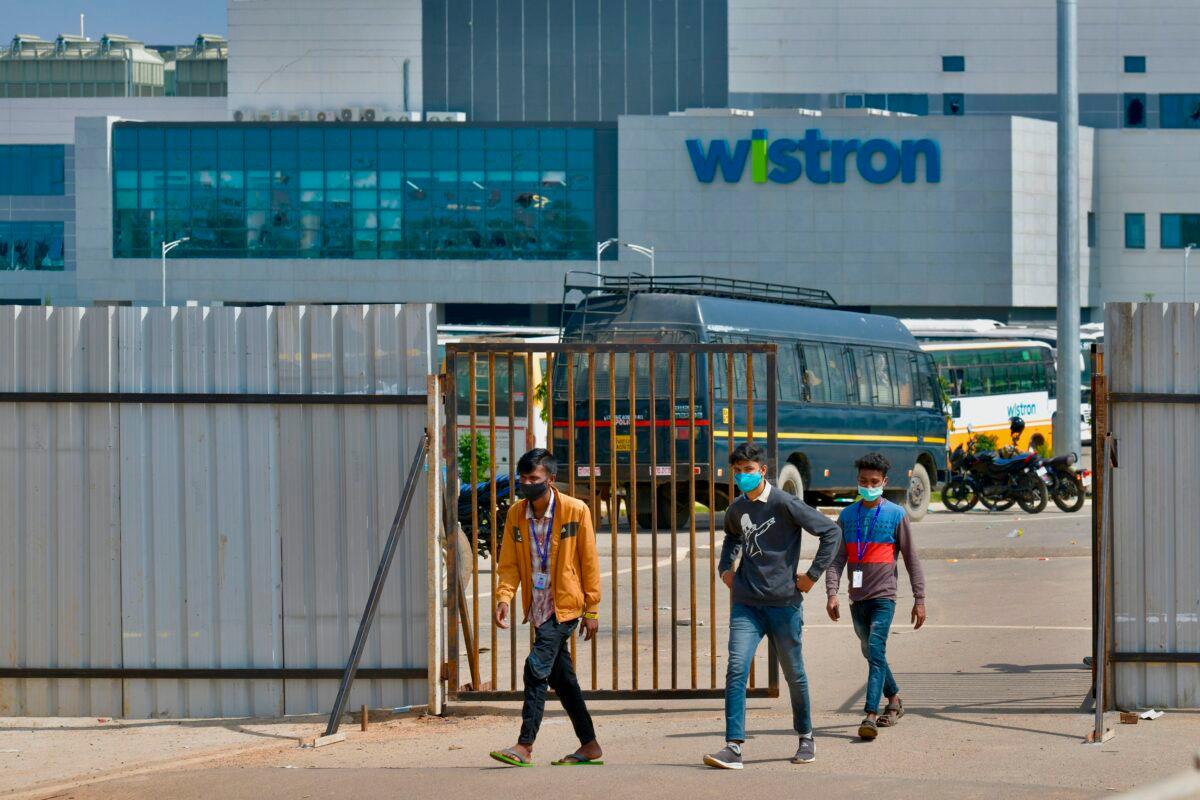 People exit from the gate of Wistron, a Taiwanese-run iPhone factory at Narsapura, about 60 km from Bangalore on Dec. 13, 2020. (Manjunath Kiran/AFP via Getty Images)