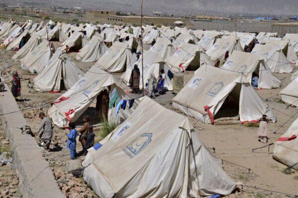 Victims of heavy flooding from monsoon rains stand beside their tents at a relief camp in Dasht near Quetta, Pakistan, Sept. 16, 2022. (The Canadian Press/Arshad Butt)