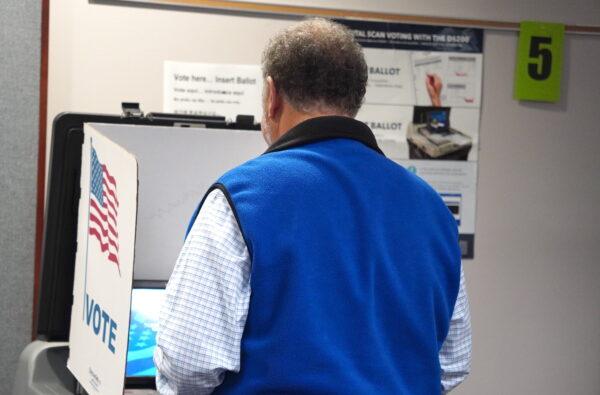 A man casts his vote during the early voting period for the midterms at the Fairfax County Government Center in Fairfax, Va., on Oct. 7, 2022. (Terri Wu/The Epoch Times)
