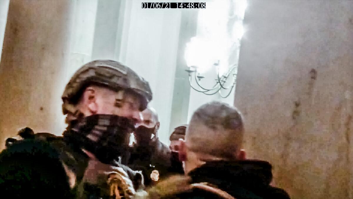 Oath Keepers member Kelly Meggs gets in between an angry protester and Capitol Police Officer Harry Dunn during an exchange in the Small House Rotunda on Jan. 6, 2021. (Stephen Horn/Screenshot via The Epoch Times)