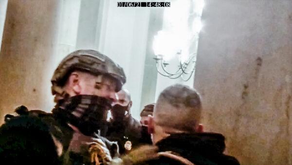 An Oath Keepers member gets in between a protester and a Capitol Police officer during a tense exchange in the Small House Rotunda on Jan. 6, 2021. (Stephen Horn/Screenshot via The Epoch Times)