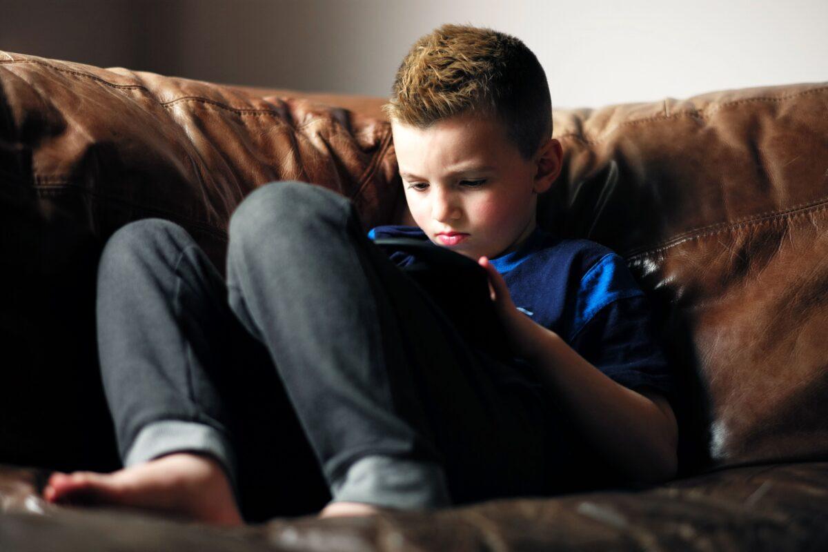 A 7-year-old transgender child plays with an iPad at home in Melrose, Mass., on May 9, 2017. (Jewel Samad/AFP via Getty Images)