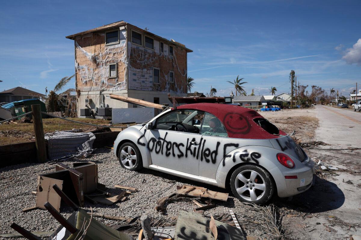 A warning to looters is painted on the side of a car destroyed during Hurricane Ian in Pine Island, Fla., on Oct. 3, 2022. (Win McNamee/Getty Images)