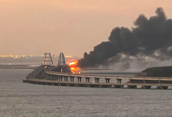 A view shows a fire on the Crimean Bridge, also called the Kerch bridge, at sunrise in the Kerch Strait, Crimea, on Oct. 8, 2022. (Stringer/Reuters)