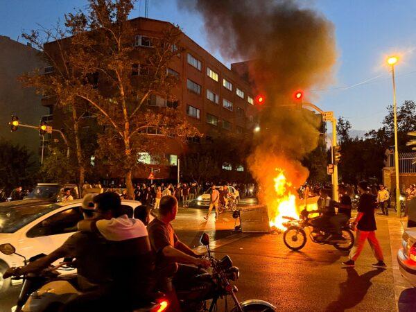 A police motorcycle burns during a protest over the death of Mahsa Amini, a young Iranian woman who died after being arrested by the Islamic republic's "morality police," in Tehran, Iran, on Sept. 19, 2022. (WANA (West Asia News Agency) via Reuters)