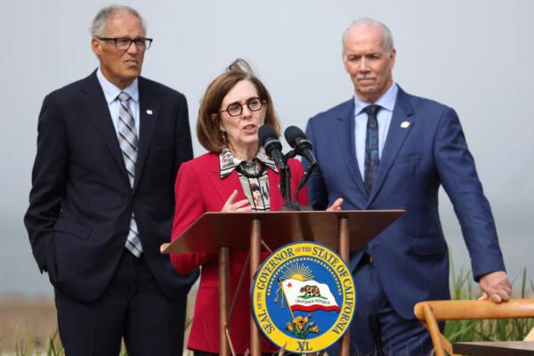 Oregon Gov. Kate Brown (C) speaks as Washington Gov. Jay Inslee (L) and British Columbia Premier John Horgan (R) look on during a press conference in San Francisco on Oct. 6, 2022. (Justin Sullivan/Getty Images)