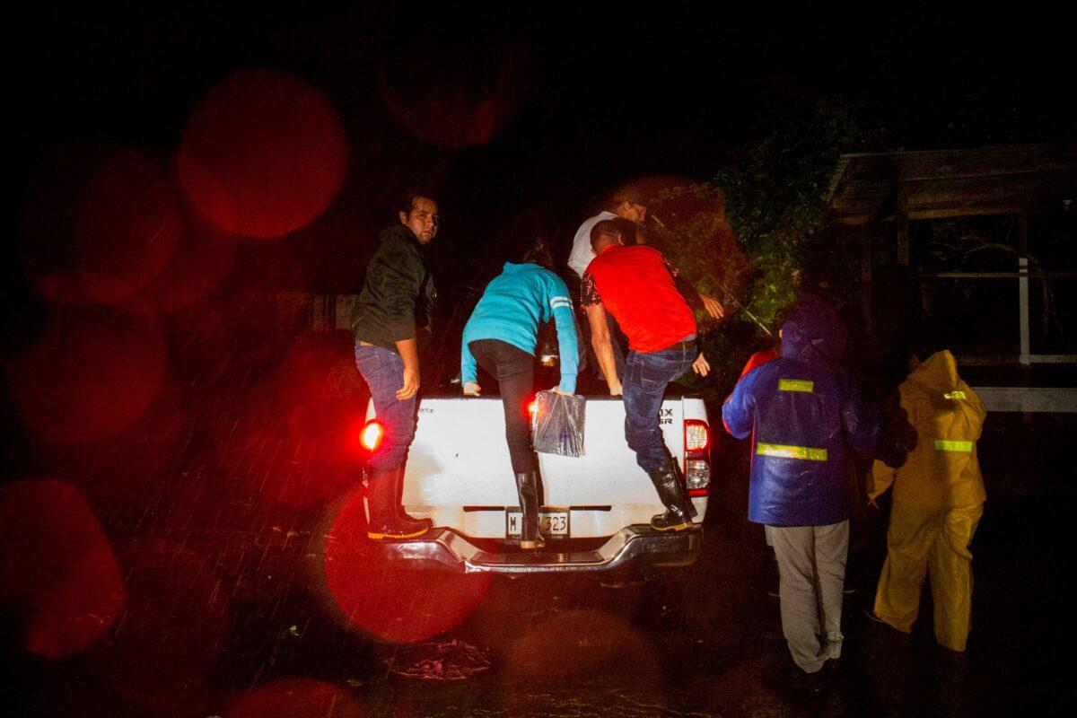 People get into a pickup truck to be transported to a safe zone while Hurricane Julia hits the coasts with wind and rain, in Bluefields, Nicaragua, on Oct. 8, 2022. (Maynor Valenzuela/Reuters)