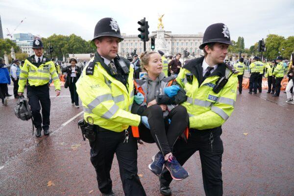 Police officers remove a campaigner from a Just Stop Oil protest on The Mall, near Buckingham Palace, London, on Oct. 10, 2022. (Jonathan Brady/PA Media)