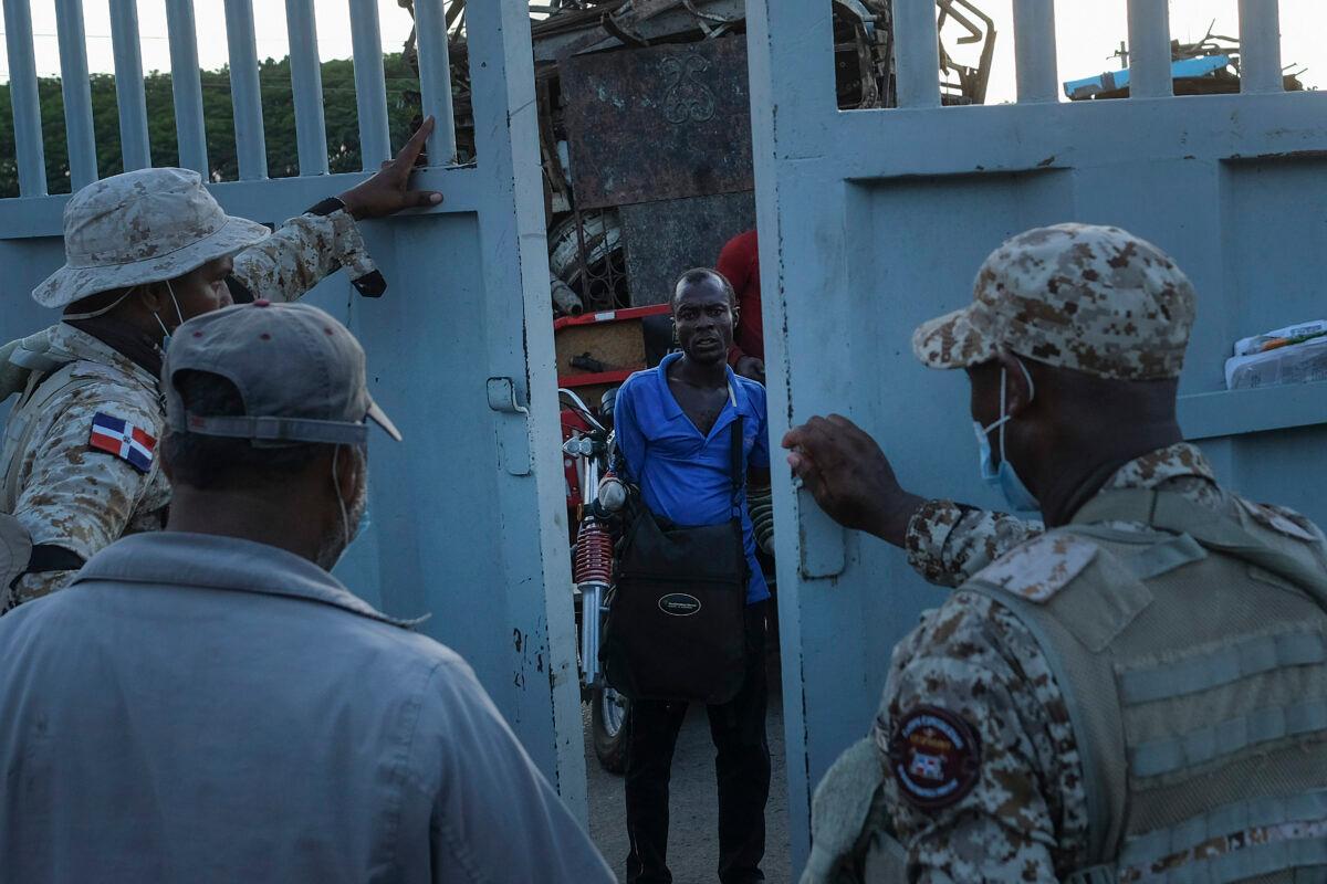 Dominican Republic soldiers close a border gate on a Haitian man who was hoping to cross into Dajabon, Dominican Republic, on Nov. 19, 2021. (Matias Delacroix/AP Photo)