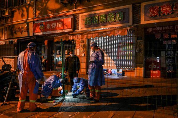 Workers erect fencing around a neighborhood in lockdown in Shanghai's Changning district on Oct. 7, 2022. (Hector Retamal/AFP via Getty Images)