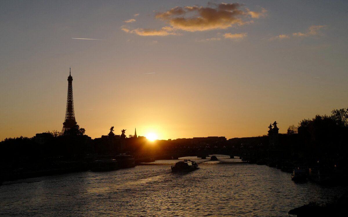 A fly boat navigates the Seine river in front of the Eiffel Tower at sunset in Paris on Oct. 8, 2022. (Ludovic Marin/AFP via Getty Images)