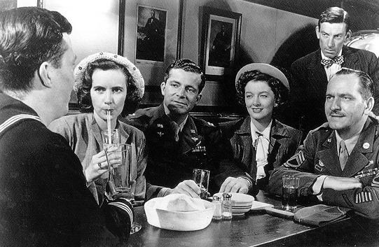 Friends, relatives, and family gather around vets returning from World War II: (L–R) Academy Award recipient Harold Russell as Petty Officer Homer, Cathy O'Donnell as his high school sweetheart Wilma, Dana Andrews as Capt. Fred, Myrna Loy as Milly, Hoagy Carmichael (back), and Frederic March as Sgt. Al in "The Best Years of Our Lives." (Samuel Goldwyn Pictures)