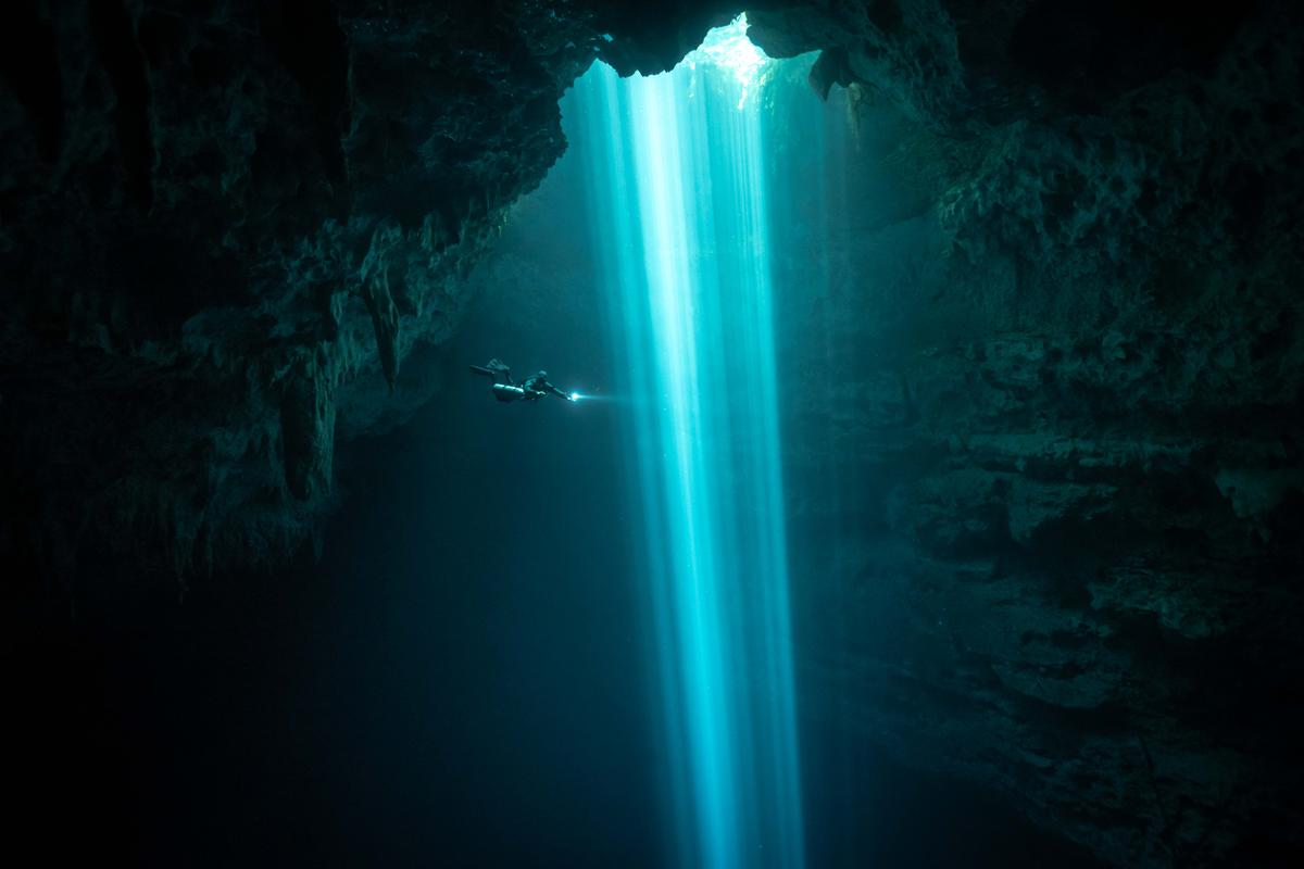 A diver descends into the deep, with light beams as their guide. (Courtesy of Brandi Mueller)