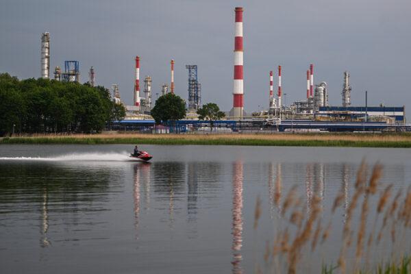 A man drives a jet ski on the Martwa river with the LOTOS Oil Refinery in the background in Gdansk, Poland, on June 6, 2022. (Omar Marques/Getty Images)
