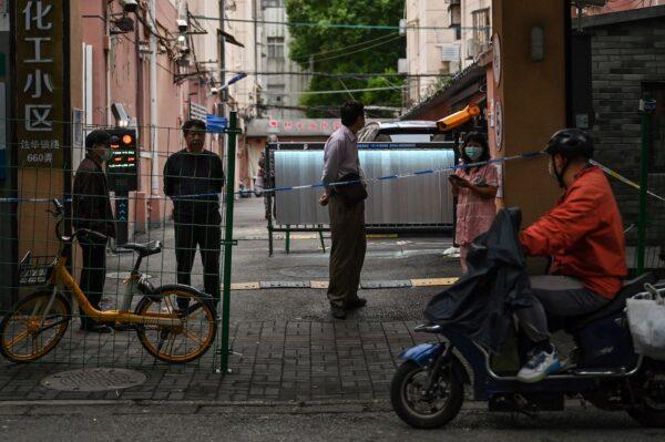 Neighbors are seen at the entrance of a compound in lockdown in the Changning district, after new COVID-19 cases were reported in Shanghai, on Oct. 8, 2022. (Hector Retamal/AFP via Getty Images)