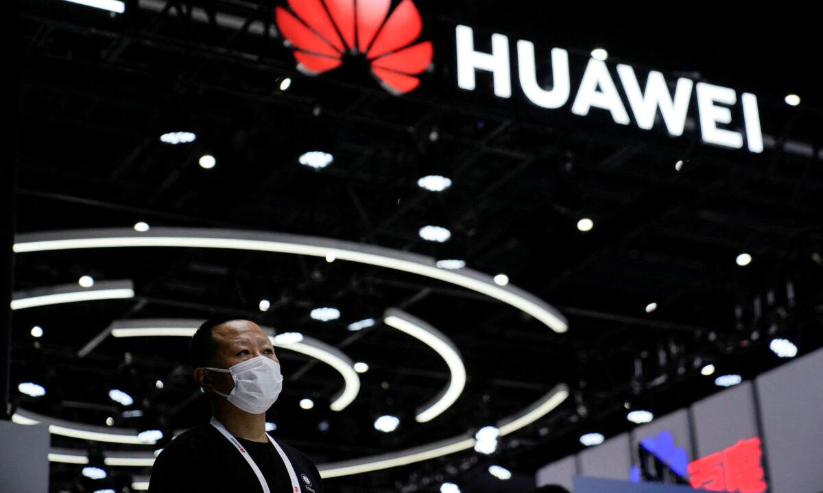 A person stands by a Huawei sign during the World Artificial Intelligence Conference in Shanghai on Sep. 1, 2022. (Aly Song/Reuters)