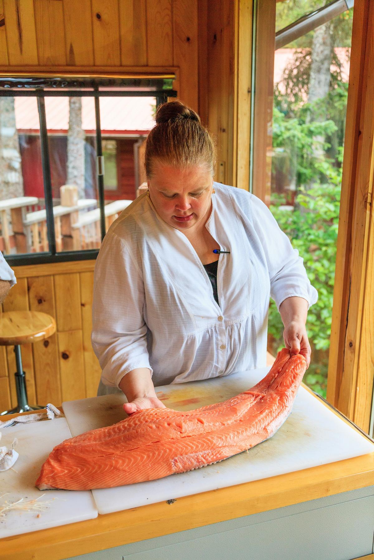 Co-owner and chef Kirsten Dixon prepares wild salmon for a cooking class. (Courtesy of Within the Wild)