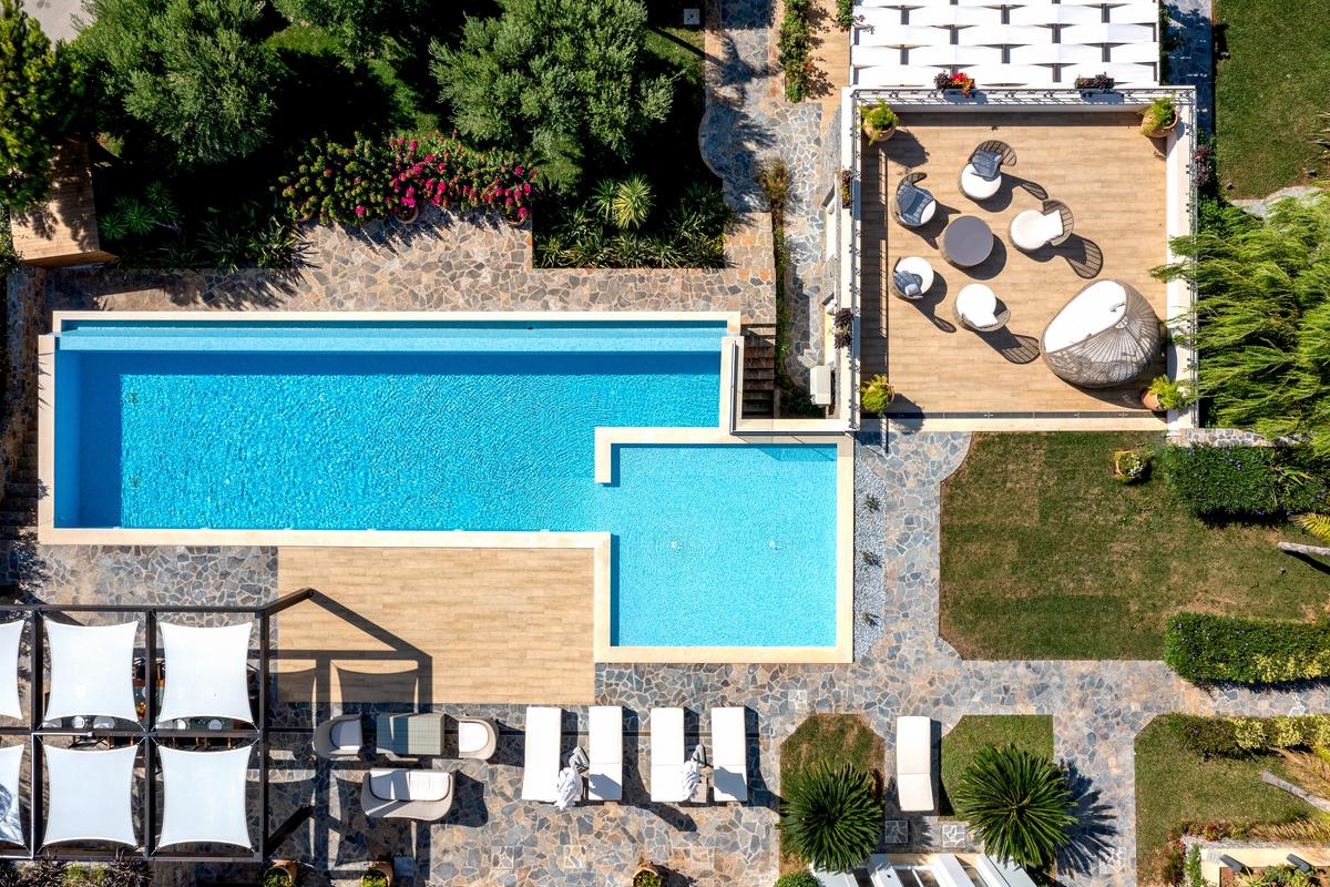 The property is improved with a huge, heated infinity pool, as well as ample al fresco dining areas, all surrounded by lush gardens. (Courtesy of Greece Sotheby's International Realty)