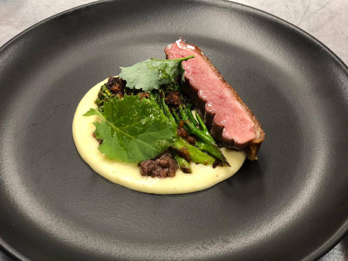 Dry-aged duck with broccolini from the garden, strawberry sofrito, polenta pecorino, and kale greens. (Courtesy of Within the Wild)