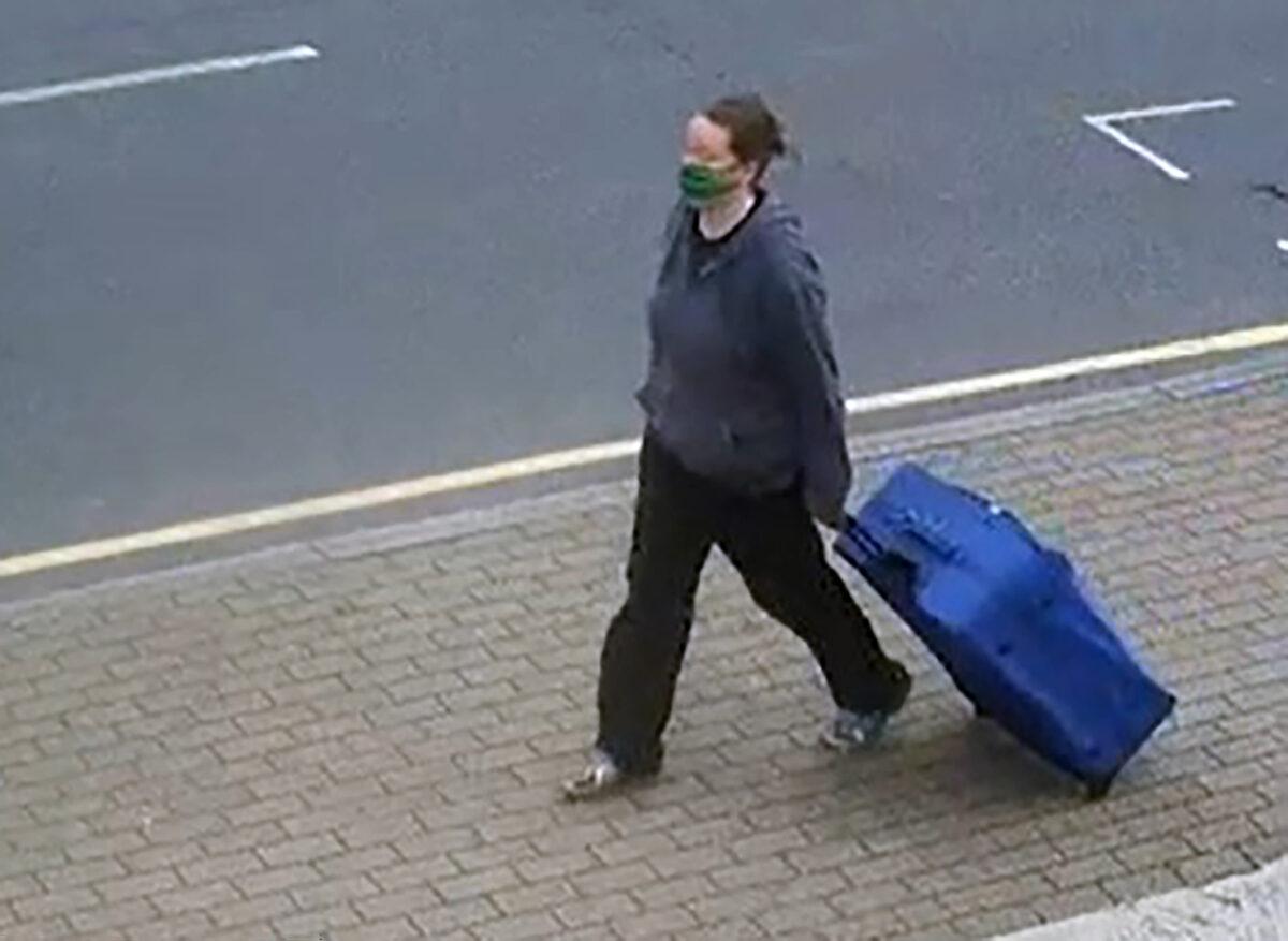 A woman. alleged to be Jemma Mitchell, is seen pulling a blue suitcase, which allegedly contained the body of Mee Kuen Chong, down a street in Wembley, north west London, on June 11, 2021 (Metropolitan Police)